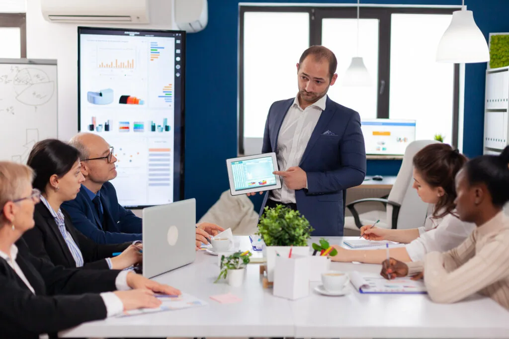 Professionals collaborating around a technology presentation